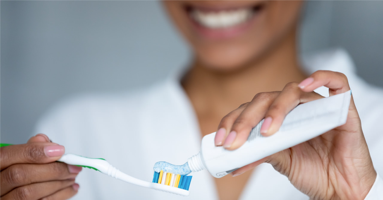 Woman putting toothpaste on a toothbrush