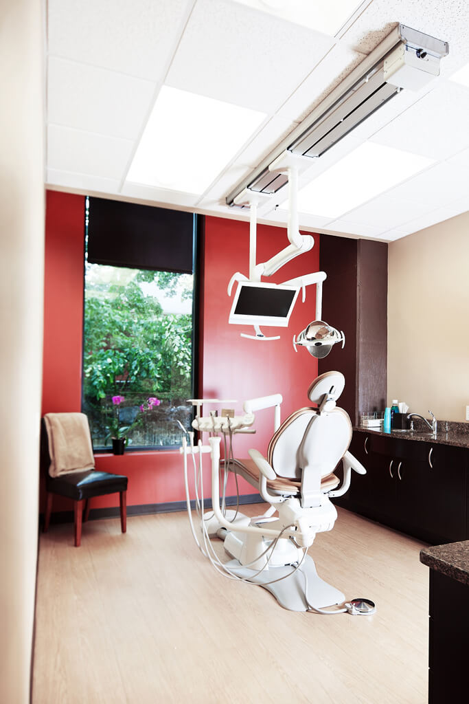 A dental office with equipment and red and tan walls