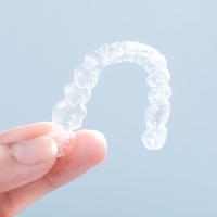 A hand holding up Invisalign